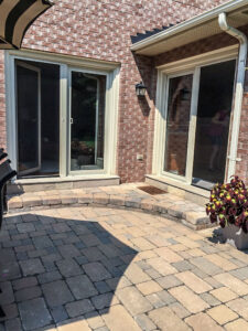 Vista One - Two Rollaway Screens two different double doors to a backyard stone patio.